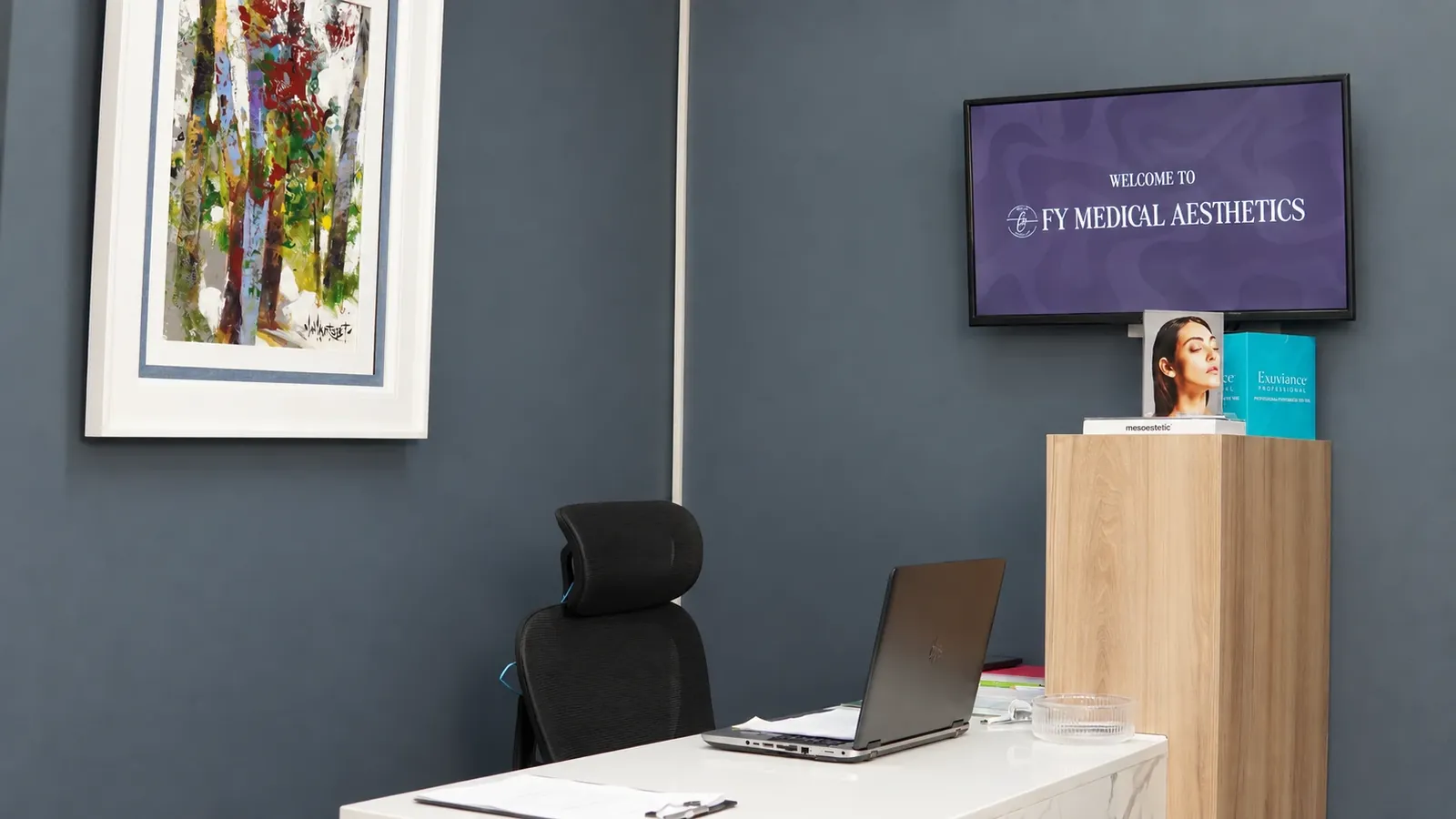 Reception desk at FY Medical Aesthetics with a welcome screen